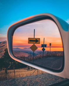 a car's rear view mirror with a road sign in the reflection