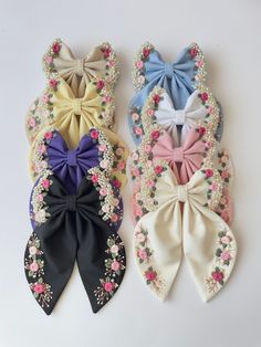 three different colored bows with flowers on them