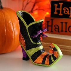 a pair of shoes sitting on top of a table next to a halloween sign and pumpkin