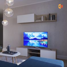 a flat screen tv sitting on top of a white table in front of a blue couch