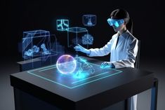 a woman wearing virtual reality glasses at a table with an object in front of her