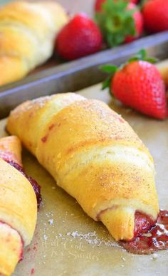 an image of some pastries on a table with strawberries and strawberrys in the background