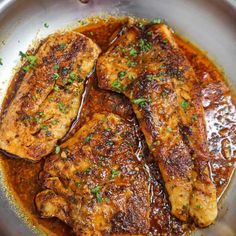 some meat is cooking in a pan on the stove top and garnished with parsley