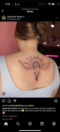 the back of a woman's neck with a cow skull and sunflower tattoo on it