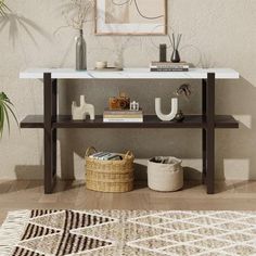 a white table with some books on top of it next to a potted plant