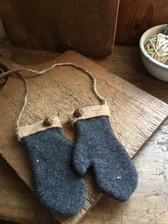 two blue mittens sitting on top of a wooden table