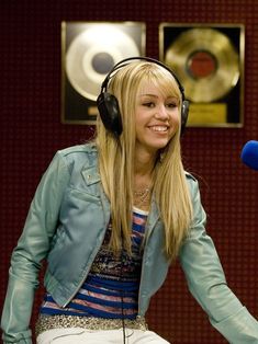 a woman with headphones sitting in front of a microphone