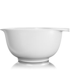 a white bowl with a spoon in it on a white surface and the lid is empty