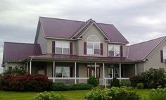 a large gray house with red shutters on the front