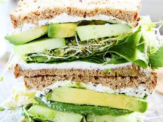 a sandwich with cucumber, lettuce and cheese