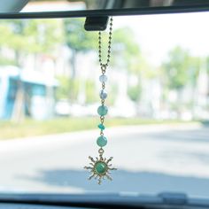 a car dashboard with a necklace hanging from it's side window