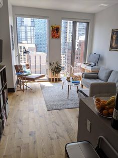 a living room filled with furniture and a flat screen tv sitting on top of a hard wood floor