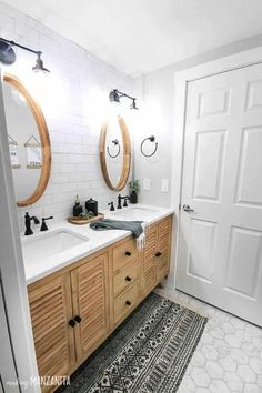 a bathroom with two sinks, mirrors and rugs on the floor in front of it