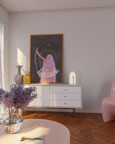 a living room filled with furniture and a painting on the wall next to a pink chair