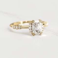 an engagement ring with a diamond in the center and two side stones on each side