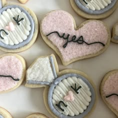 decorated cookies are arranged in the shape of heart and mouses with letters on them