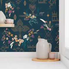 the wallpaper in this room is painted with flowers and leaves, while the vases are