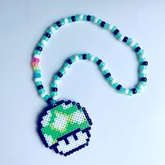 a beaded necklace with a green and white broccoli pendant on it's end