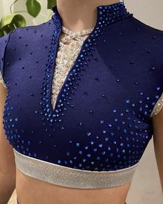 a woman wearing a blue and white top with sequins on it