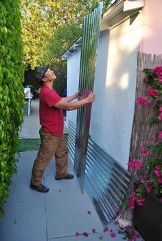 a man is painting the side of a building with flowers on it and he has his eyes closed