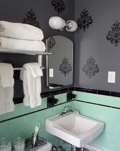 a white sink sitting under a bathroom mirror next to a towel dispenser