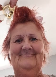 an older woman with red hair is smiling