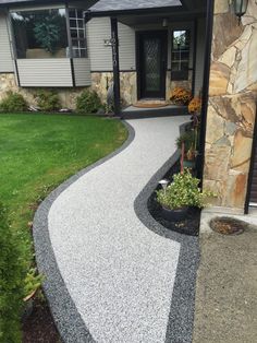 a driveway with gravel and grass in front of a house