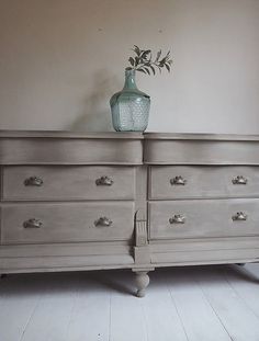 an old dresser has a vase on top