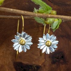 Handcrafted and unique Scottish Daisy earrings made from Sterling Silver with 18ct gold detailing highlighted on the stamen and stalk. These new daisy earrings are part of our Spring jewellery collection, inspired by the native Scottish flower. These earrings are hand finished to give an elegant and stunning brushed finish to the flower. These delicate earrings are a beautiful addition to any jewellery collection. Perfect for spring, summer, bridal jewellery and bridesmaid gifts. * A high-quality, unique product * Sold as PAIR * Ethically traded sterling silver * Matching pendant and set with a discount also available * Ships direct from Edinburgh, Scotland * Supports a small artisan business Vermeil is a technique originating in the 19th century, where gold is applied to sterling silver - Scottish Flowers, Black Tungsten Rings, Flower Drop Earrings, Spring Jewelry, Daisy Earrings, Bridal Jewellery, Delicate Earrings, Matching Necklaces, Earrings Sterling Silver