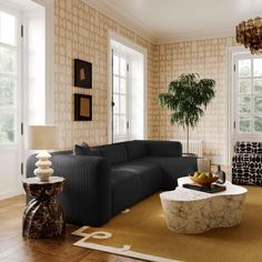 a living room with a couch, coffee table and potted plant in the corner