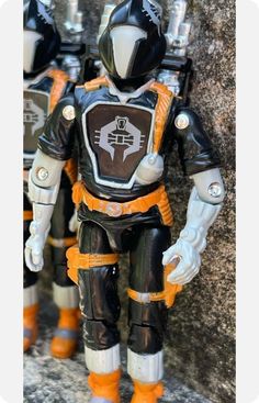 the action figure is wearing an orange and black suit with white accents on it's chest