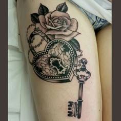 a woman's thigh with a rose and key tattoo on it