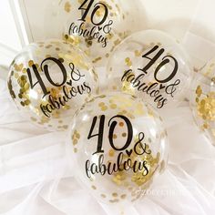 four clear balloons with gold confetti and black lettering on them that say 40 fabulous fabulous fabulous