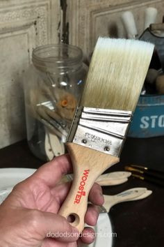 a person holding a paint brush in their hand