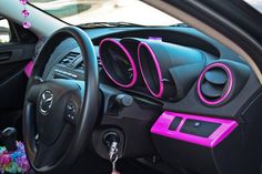 the interior of a car with pink trim and steering wheel controls on it's dashboard