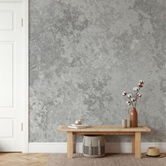 a wooden table sitting in front of a gray wall