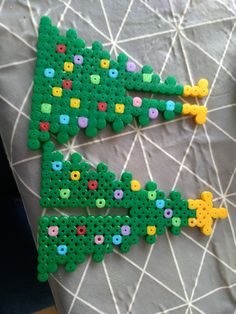 two pieces of plastic beaded are sitting on a bed with the letters e and f