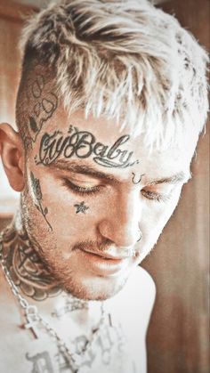 a man with tattoos on his face looking down