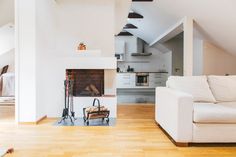 a living room filled with furniture and a fire place next to a white couch on top of a hard wood floor