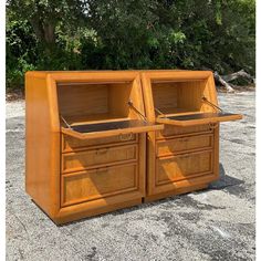 two wooden cabinets sitting side by side on gravel