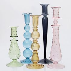 five different colored vases are lined up in the same row and one is empty