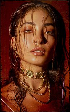 a woman with long hair wearing gold jewelry