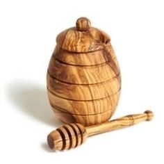 a wooden honey pot with a wooden stick in front of it on a white background