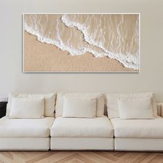 a white couch sitting in front of a painting on the wall