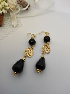 Beautiful handmade earrings with black agate beads and 18K gold plated metal components. For this creation I was inspired by the classic 50s style. I used the contrast of gold and black colors which makes the earrings very elegant. The earrings are long, very elegant and romantic thanks to the floral elements as connectors. Suitable for an elegant evening dress for an important party. They match with some long agate necklaces that I offer in my shop. All jewels are delivered in a decorated box, ready to be given as a gift to your loved one. How to take care of your jewellery: put on your beauty products (cosmetics, perfumes, ...) before wearing your precious jewel. Clean your jewelry with a soft cloth after wearing. Don't use water. Make sure you store your jewelry separately to avoid scra Elegant Onyx Earrings For Party, Gold Onyx Earrings For Evening, Black Beads Drop Earrings For Evening, Black Beaded Drop Earrings For Evening, Black Gold-plated Pierced Earrings, Black Gold-plated Earrings, Evening Black Beaded Drop Earrings, Black Gold-plated Earrings For Gift, Gold Onyx Earrings For Pierced Ears