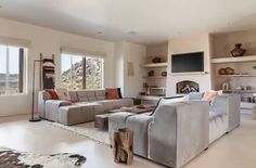 a living room filled with furniture and a flat screen tv mounted to the wall over a fireplace