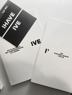 two pieces of paper with black and white lettering on them sitting next to each other