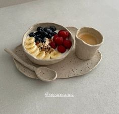 a bowl of fruit, yogurt and granola on a plate