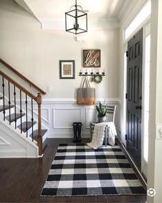 a black and white checkered rug is on the floor in front of a staircase