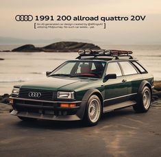 an audi quattro is parked on the beach next to the ocean and rocks